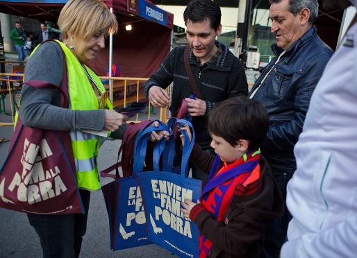 Los aficionados azulgranas recogiendo las bolsas solidarias ayer en el Camp Nou. Foto: German Parga