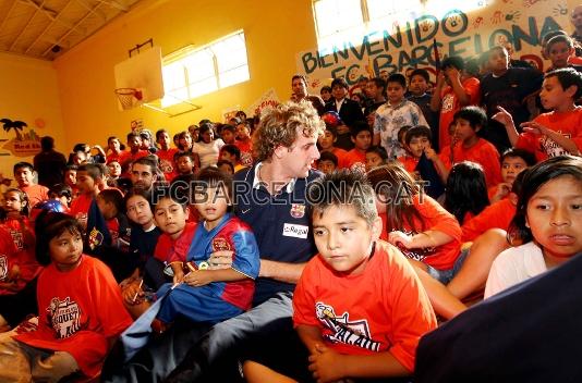 Los jugadores del Regal Barça con los niños del centro social.