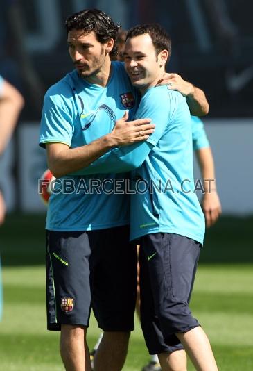 Zambrotta e Iniesta se abrazan en un momento del entrenamiento.