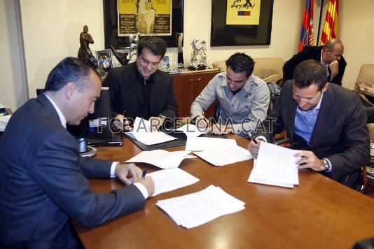El vicepresident Rafael Yuste, el president Joan Laporta, Xavi i el seu representant, Ivan Corretja, en el moment de la signatura.