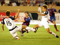 Luis Garca, tapat per dos jugadors del Kashima durant la gira asitica de l'any 2004. Fotos: Arxiu FCB