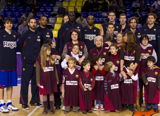 Els jugadors del Regal FC Barcelona amb els infants, al parquet del Palau. Foto: lex Caparrs / FCB