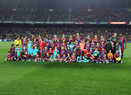 Els jugadors del Bara, envoltats de nens abans d'un partit. Foto: Arxiu FCB.