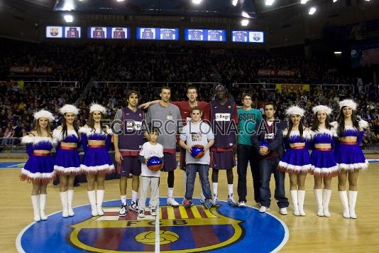 Les 'cheerleaders' i els jugadors del Regal Bara amb els guanyadors del concurs. (Foto: lex Caparrs - FCB)