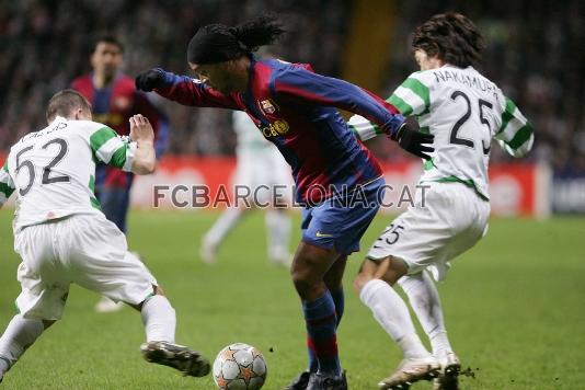 Ronaldinho intenta driblar dos jugadors alhora.