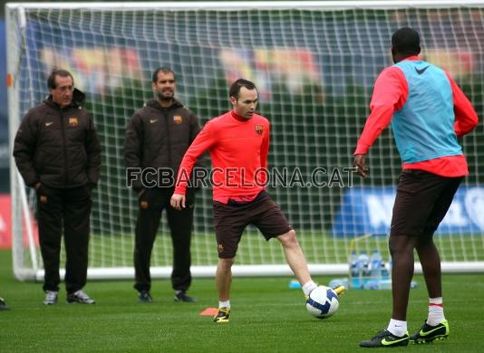 Andrs Iniesta amb la pilota, mentre Guardiola s'ho mira.