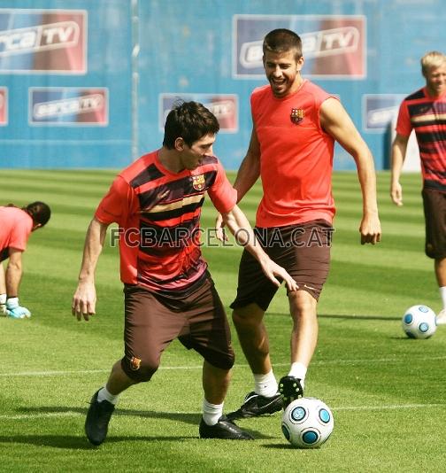 Leo Messi se lleva un baln, ante la presin de Piqu.