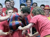 Momento en el que Puyol y Piqu le ponen la camiseta del Bara a Cesc.